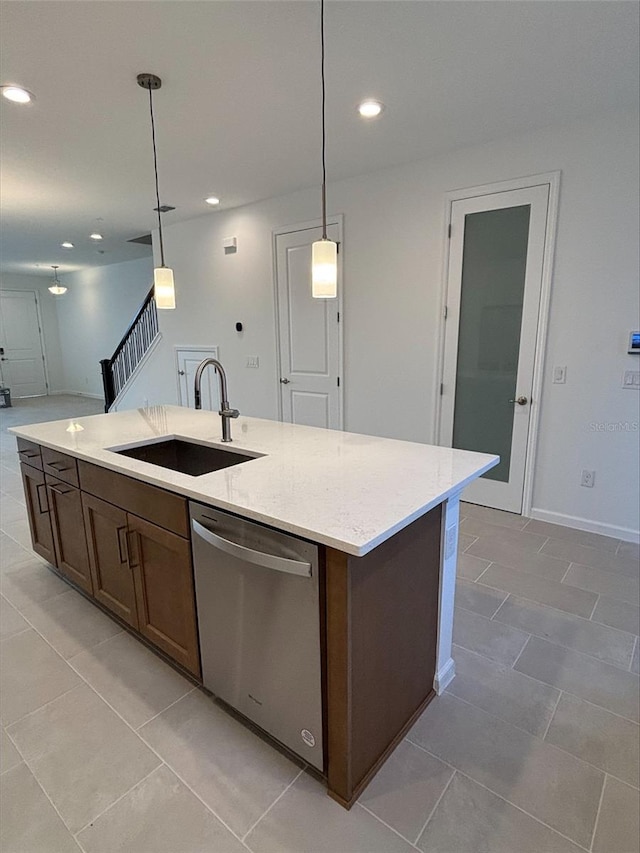 kitchen featuring dishwasher, pendant lighting, a center island with sink, and sink