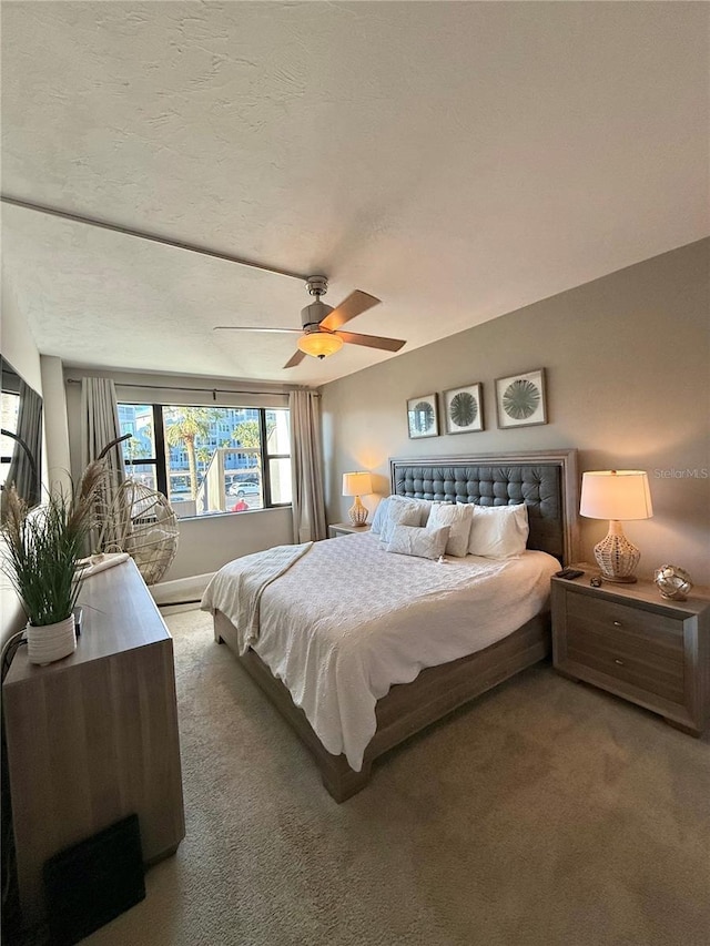 carpeted bedroom featuring a textured ceiling and a ceiling fan