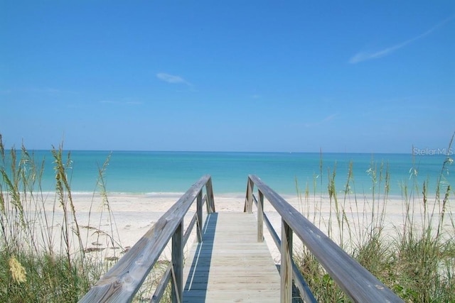 view of property's community featuring a water view and a beach view