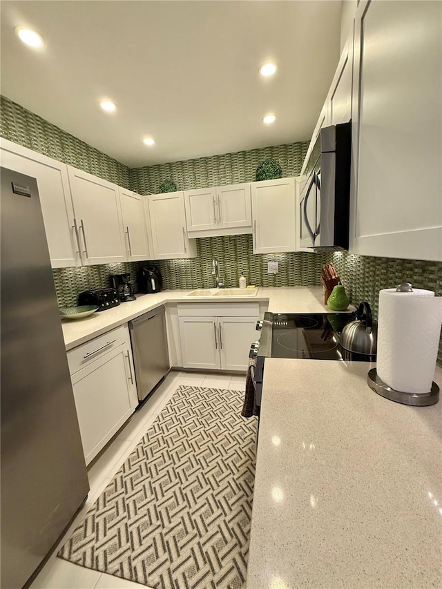5855 Midnight Pass Rd Unit 108, Sarasota, FL 34242 - kitchen featuring stainless steel appliances, a sink, white cabinetry, recessed lighting, and backsplash