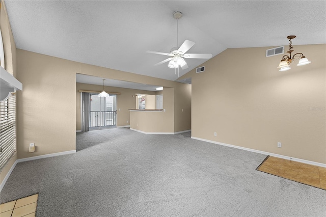 unfurnished living room with ceiling fan with notable chandelier, carpet floors, and lofted ceiling