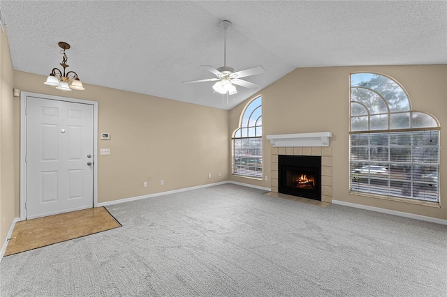 unfurnished living room featuring carpet flooring, vaulted ceiling, and a healthy amount of sunlight