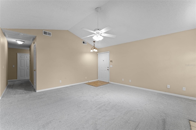 carpeted empty room featuring a textured ceiling, ceiling fan, and lofted ceiling