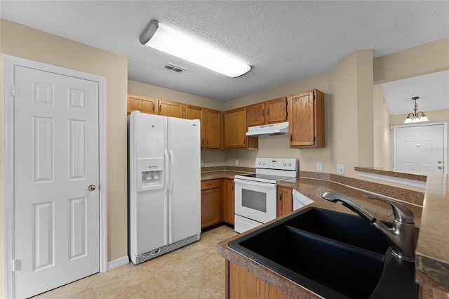 kitchen with kitchen peninsula, white appliances, sink, a chandelier, and hanging light fixtures