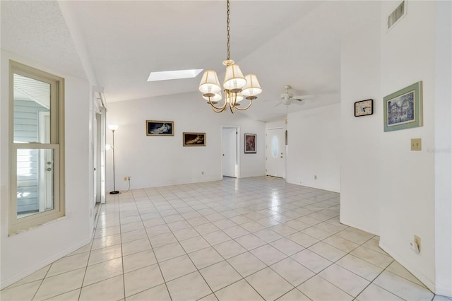 tiled empty room with ceiling fan and vaulted ceiling with skylight