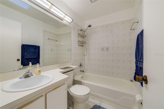 full bathroom with tile patterned flooring, vanity, tiled shower / bath combo, and toilet