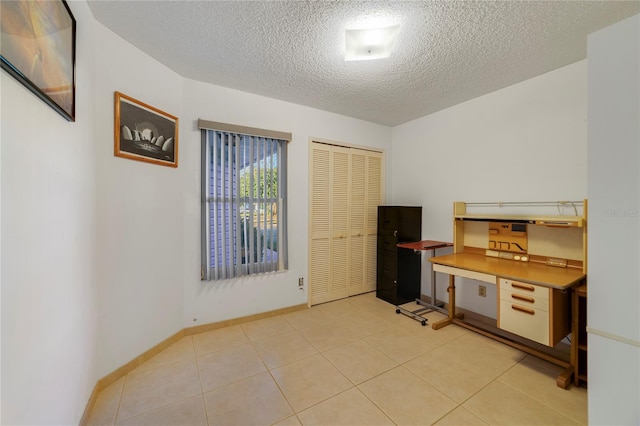 office area featuring light tile patterned flooring and a textured ceiling