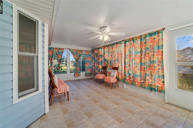 unfurnished sunroom featuring ceiling fan