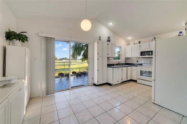 kitchen with light tile patterned floors, white appliances, white cabinetry, hanging light fixtures, and vaulted ceiling