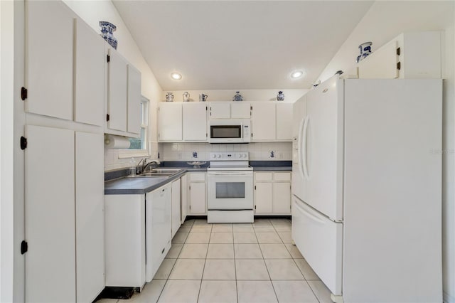 kitchen featuring sink, white appliances, light tile patterned floors, white cabinetry, and tasteful backsplash