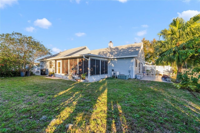 rear view of house featuring a yard, a patio area, a sunroom, and central air condition unit