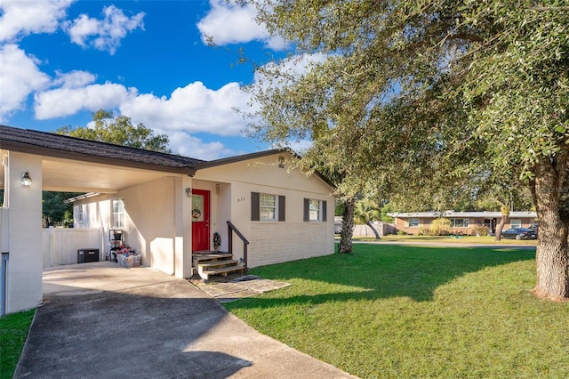 view of front facade with a carport, central air condition unit, and a front lawn