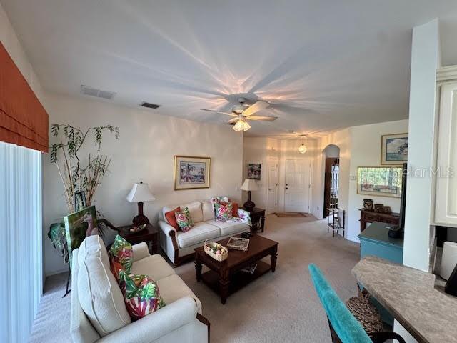 living room featuring ceiling fan and light colored carpet