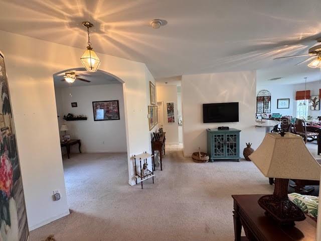 carpeted living room featuring ceiling fan