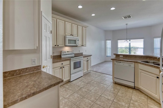 kitchen featuring decorative light fixtures, white appliances, sink, and light tile patterned floors