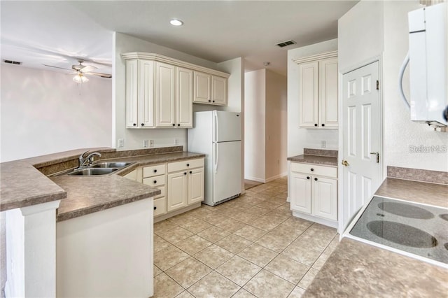 kitchen featuring white appliances, ceiling fan, sink, light tile patterned floors, and cream cabinetry