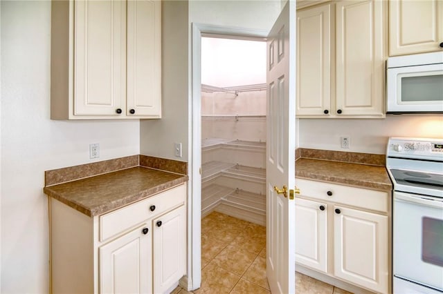 kitchen with light tile patterned flooring and white appliances