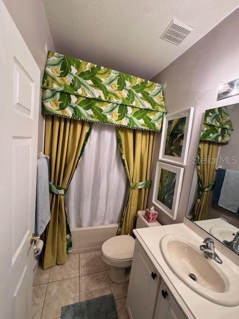 full bathroom featuring a textured ceiling, vanity, shower / bath combo, and toilet