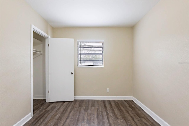 unfurnished bedroom featuring a closet and dark wood-type flooring