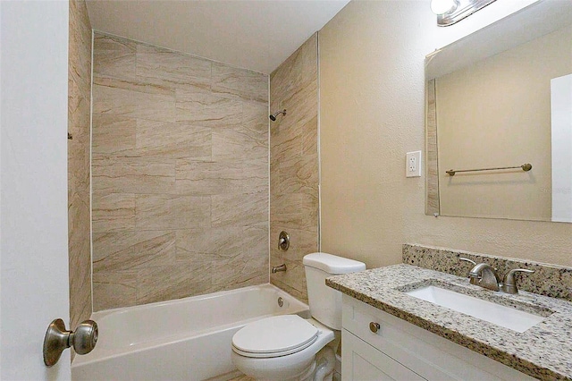 full bathroom featuring vanity, tiled shower / bath combo, and toilet