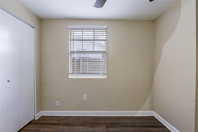 empty room with dark hardwood / wood-style flooring and ceiling fan