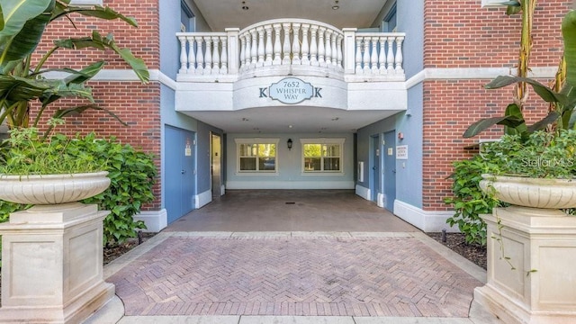 view of exterior entry featuring a balcony