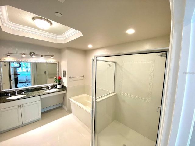 bathroom featuring a tray ceiling, vanity, independent shower and bath, and ornamental molding