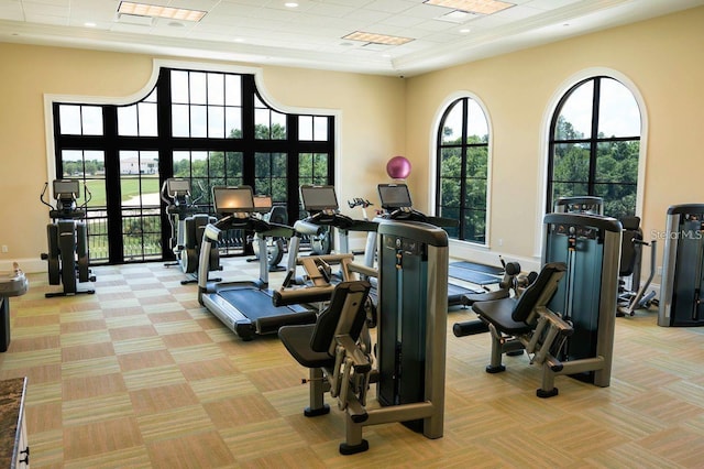 gym with a high ceiling and light colored carpet