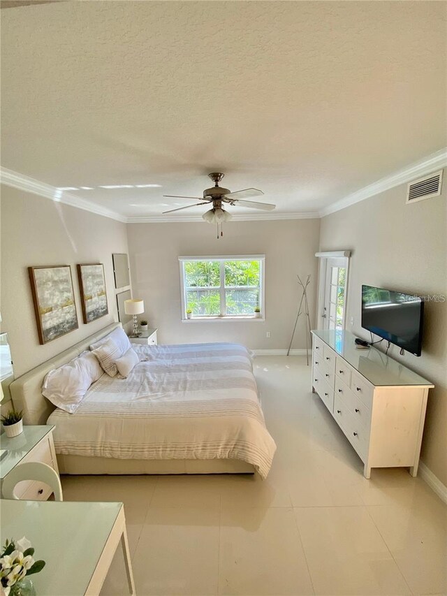 bedroom featuring visible vents, crown molding, a textured ceiling, and baseboards