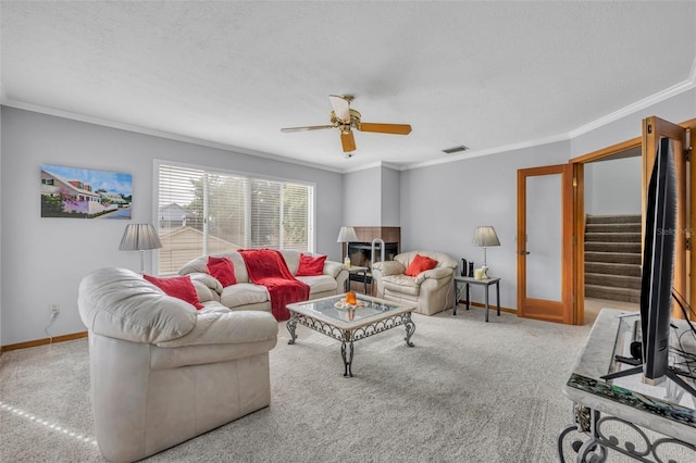 living room featuring a textured ceiling, ceiling fan, light colored carpet, and crown molding