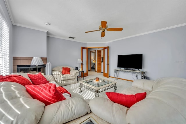 carpeted living room with a fireplace, ceiling fan, and crown molding