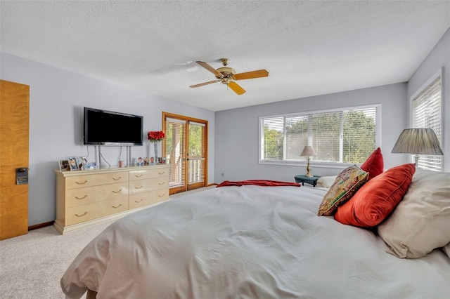 carpeted bedroom featuring ceiling fan and a textured ceiling