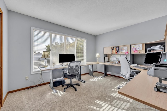 carpeted office featuring a textured ceiling