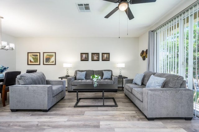 living room with ceiling fan and light hardwood / wood-style flooring