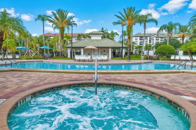 view of pool with a hot tub