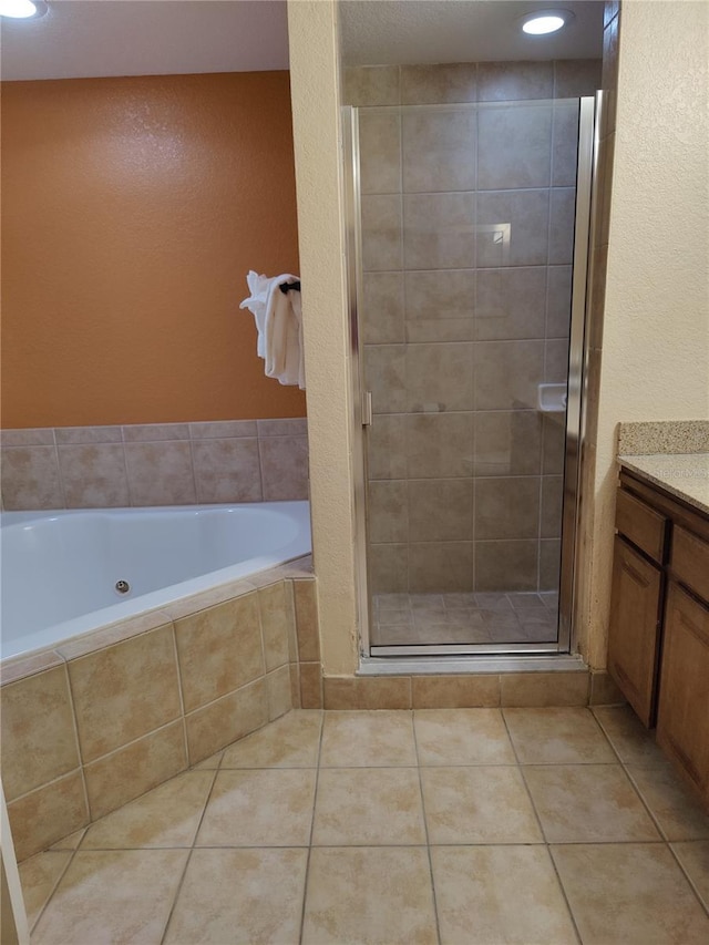 bathroom with tile patterned floors, vanity, and shower with separate bathtub