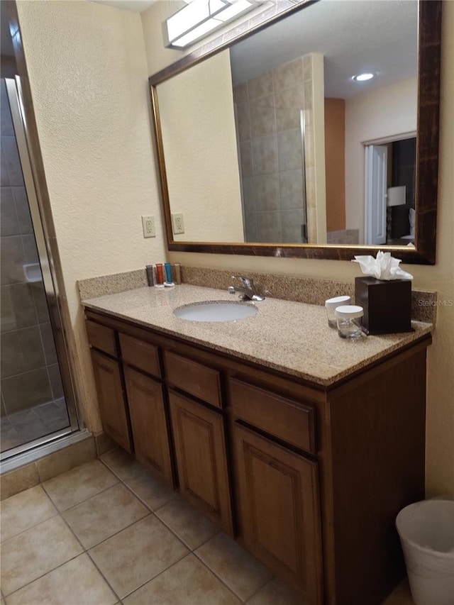 bathroom featuring tile patterned flooring, vanity, and a shower with shower door