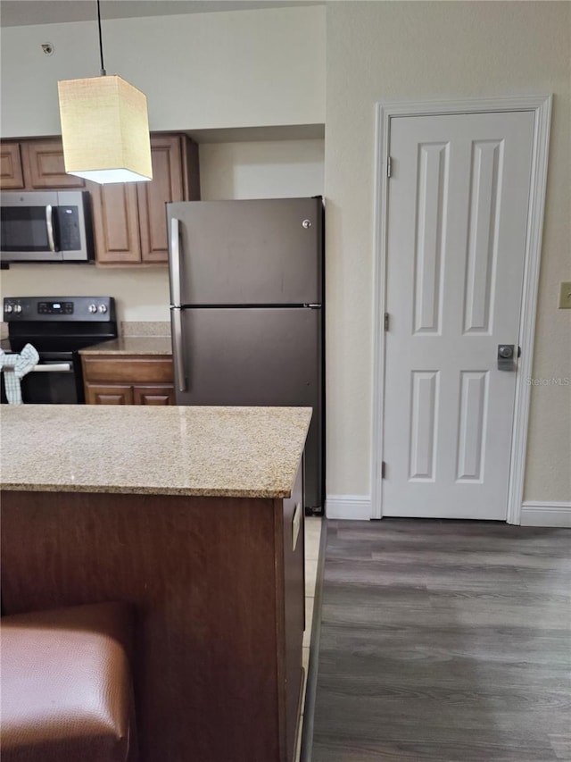 kitchen with stainless steel appliances, hanging light fixtures, and dark wood-type flooring