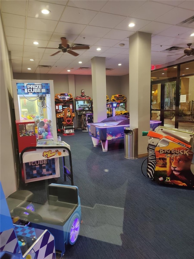 rec room featuring ceiling fan, a drop ceiling, and carpet floors