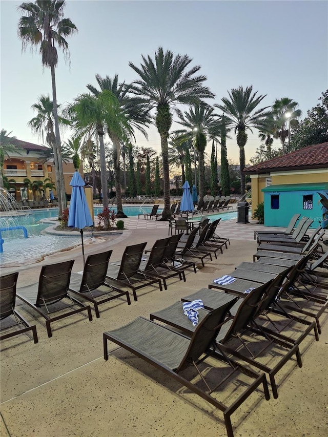 pool at dusk featuring a patio area