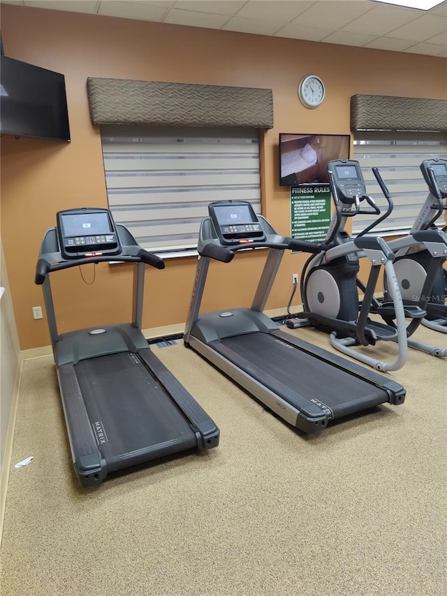 gym with carpet flooring and a paneled ceiling