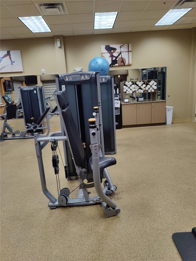 workout area with carpet flooring and a drop ceiling