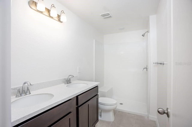 bathroom featuring tile patterned floors, vanity, toilet, and walk in shower