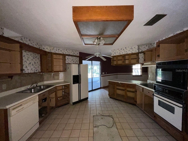 kitchen featuring white appliances, ceiling fan, and sink