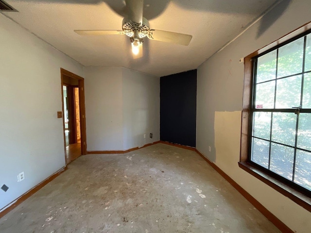 spare room with ceiling fan and concrete floors