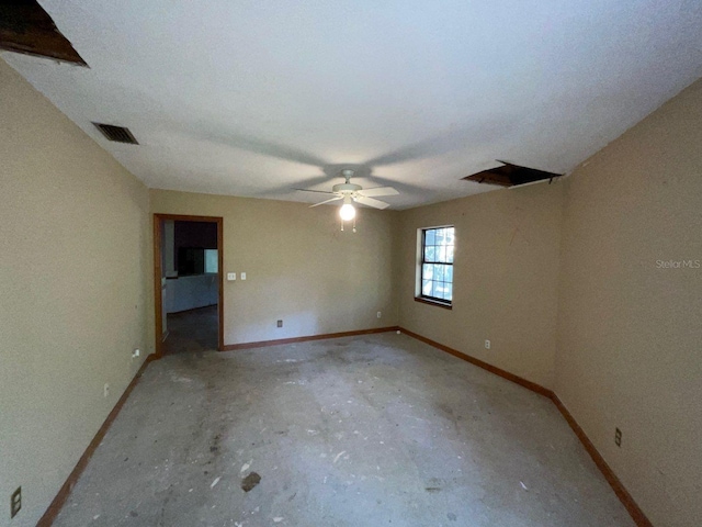 unfurnished room with ceiling fan and concrete flooring