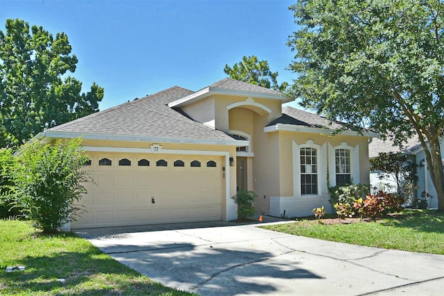 view of front of house with a front yard and a garage