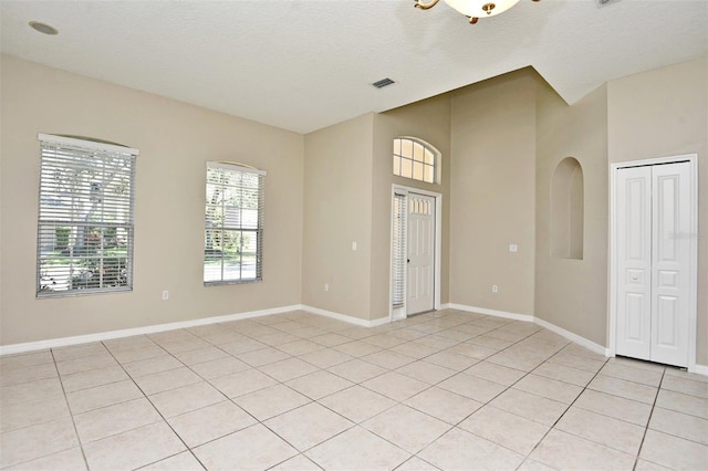 tiled spare room with a textured ceiling