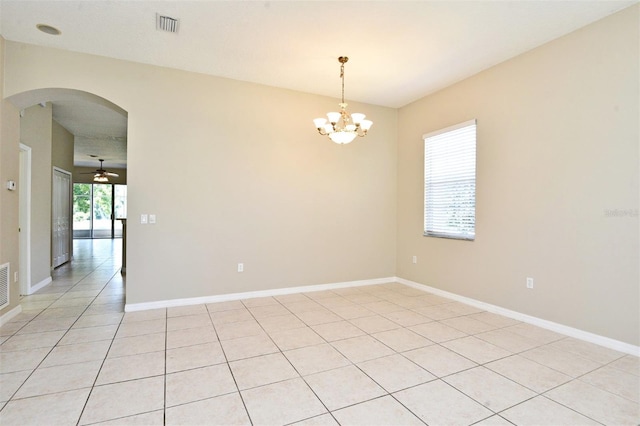 spare room with ceiling fan with notable chandelier and light tile patterned floors