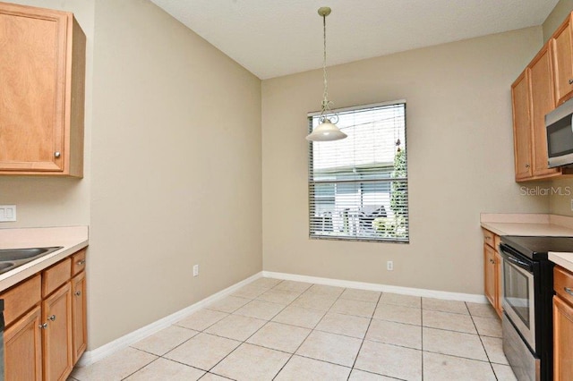 kitchen featuring decorative light fixtures, light tile patterned floors, light countertops, appliances with stainless steel finishes, and baseboards